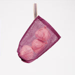 A small, transparent burgundy vegetable bag, made by Ban Inoue using traditional mosquito net weaving techniques. Made in Japan, it’s a simple rectangle shape with stitched corners at the bottom for structure. One corner features a braided cord to hang it with. Available at NiMi Projects UK.