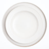 A top view of a Kihon no Utsuwa recycled porcelain side dish in white on top of a flat round plate by the same maker. Made in Japan and available at NiMi Projects UK.