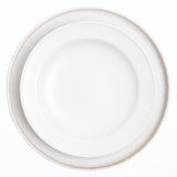 A top view of a Kihon no Utsuwa recycled porcelain side dish in white on top of a flat round plate by the same maker. Made in Japan and available at NiMi Projects UK.