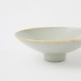 A closeup image of a Kihon no Utsuwa porcelain rice bowl or side dish in duck-egg blue, featuring a small platform base. Made in Japan and available at NiMi Projects UK.