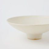 A closeup image of a Kihon no Utsuwa porcelain rice bowl or side dish in creamy white, featuring a small platform base. Made in Japan and available at NiMi Projects UK.