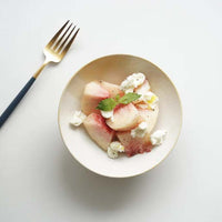 A serving of peach salad in a creamy white Kihon no Utsuwa Japanese porcelain rice-bowl shaped dish.