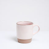 A Mino-yaki, Japanese porcelain, stacking mug, featuring a soft, pastel pink satin glaze and an unglazed base and lip. Available at NiMi Projects UK.