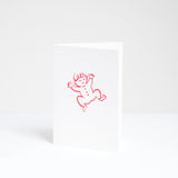 A congratulations card for a new baby, designed by Takako Copeland and featuring a red line drawing of a smiling baby in a romper suit. Available at NiMi Projects UK.