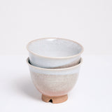 Two stacked vintage Hagi-yaki (rustic style) Japanese ceramic teacups, featuring an orange clay base, crackle glaze and decorative drip white glaze. Available at NiMi Projects UK.