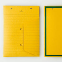 An top view of two Postalco Snap Pocket envelopes in mustard yellow, featuring holes at the top to attach to a Snap Pad. One side is lined and features the Postalco bird logo at the top, the other side is plain yellow with a dark green border.