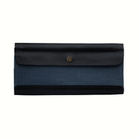 A Postalco Tool Box pen case, featuring a navy blue, soft, cowhide leather top with metal snap clasp and a central navy blue panel of cotton canvas.