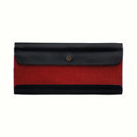 A Postalco Tool Box pen case, showcasing a navy blue, soft, cowhide leather top with metal snap clasp and a central panel of red cotton canvas.
