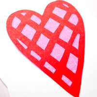 A closeup image of a Takako Copeland illustration of a pink heart patterned with a red check.