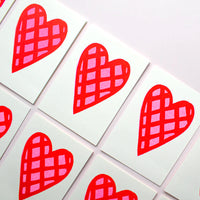 A group of Valentines cards illustrated with giant pink hearts decorated with a red check pattern on a white background. Designed by Takako Copeland and available at NiMi Projects UK.